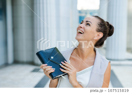 Successful businessman or entrepreneur smiling holding notepad while walking Successful businessman or entrepreneur smiling holding notepad while walking 107515819