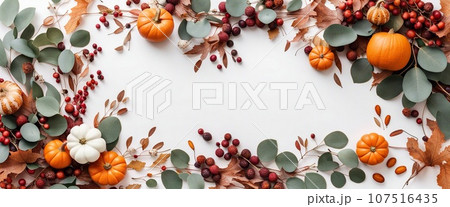 Thanksgiving day or Halloween concept banner. Top view white background decor from pumpkin, red berry, green leaves with copy space. autumn and fall season background. Thanksgiving day or Halloween concept banner. Top view white background decor from pumpkin, red berry, green leaves with copy space. autumn and fall season background. 107516435
