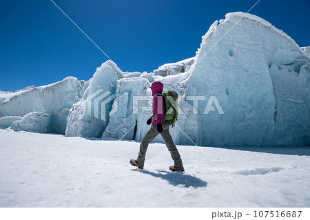 Woman hiker hiking in winter huge glacier mountain,China 107516687