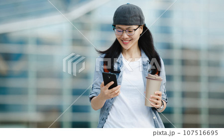 People use mobile phone walking with coffee cup in hand People use mobile phone walking with coffee cup in hand 107516695