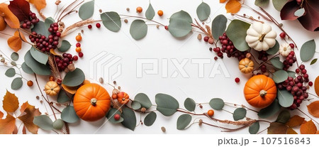 Thanksgiving day or Halloween concept banner. Top view white background decor from pumpkin, red berry, green leaves with copy space. autumn and fall season background. 107516843