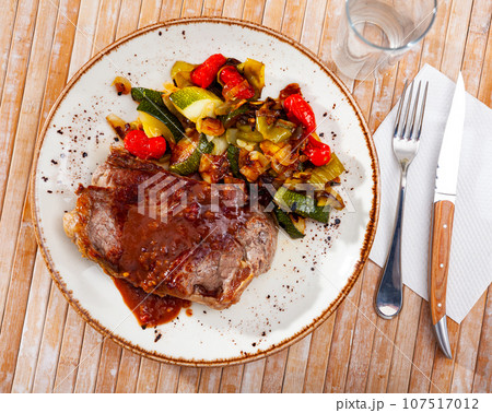 Beef steak with sauce, baked zucchini, bell pepper and onion Beef steak with sauce, baked zucchini, bell pepper and onion 107517012