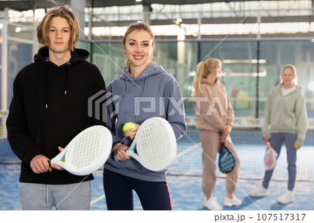 Teenage boy and young woman in padel court 107517317