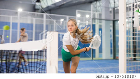 Girl tennis player playing padel tennis Girl tennis player playing padel tennis 107518187