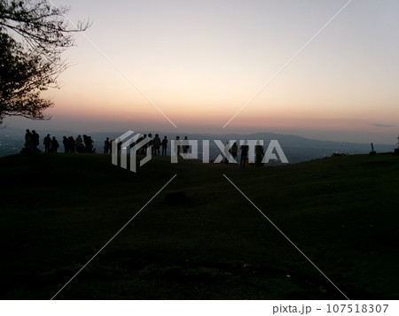 奈良秋の若草山の山頂で夕暮れを鑑賞する沢山の人々 107518307