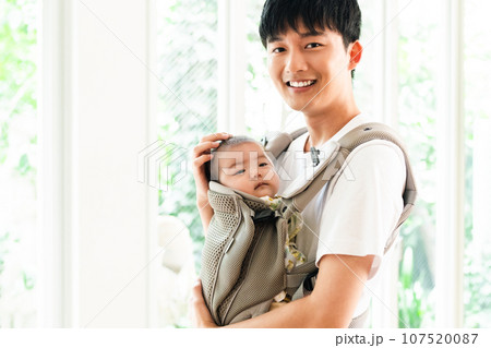 赤ちゃんをあやす若いパパ 107520087