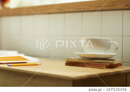 A comfortable room where warm afternoon sunlight comes in through a window with a view of tree leaves. 107520356