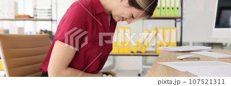 Office worker suffers from stomach ache at workplace 107521311