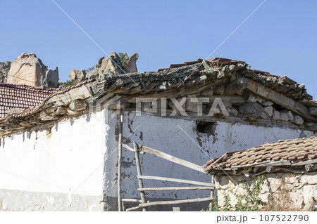 Old broken roof of a village house with white walls Old broken roof of a village house with white walls 107522790