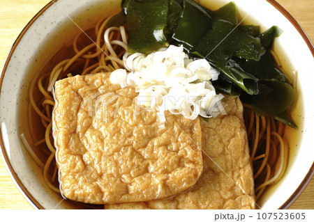油揚げ2枚とワカメと葱が乗ったきつね蕎麦を俯瞰で撮影 107523605