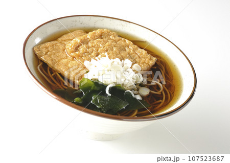 油揚げ2枚とワカメと葱が乗ったきつね蕎麦を白背景で撮影 油揚げ2枚とワカメと葱が乗ったきつね蕎麦を白背景で撮影 107523687