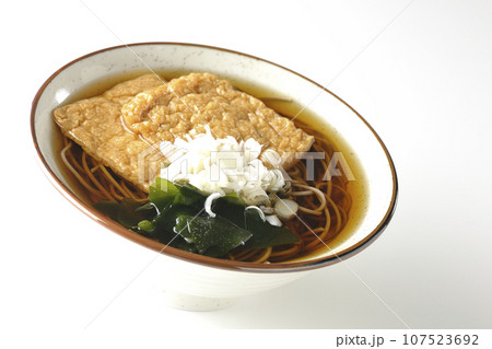 油揚げ2枚とワカメと葱が乗ったきつね蕎麦を白背景で撮影 107523692
