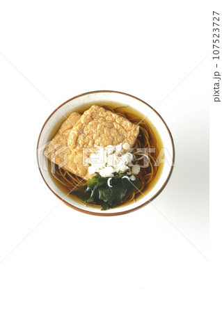 油揚げ2枚とワカメと葱が乗ったきつね蕎麦を白背景で俯瞰撮影 油揚げ2枚とワカメと葱が乗ったきつね蕎麦を白背景で俯瞰撮影 107523727