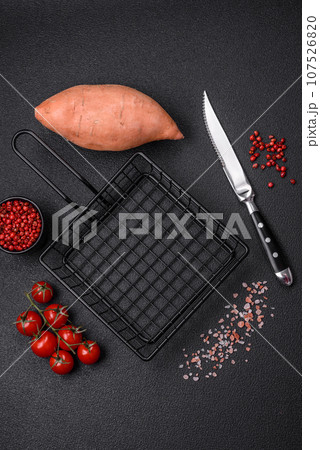 A black mesh or basket for deep-frying and cooking potatoes in boiling oil 107526820