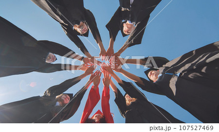 The happy graduates join hands and disperse. 107527469