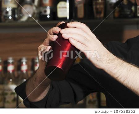 barkeeper mixing drinks together in a bar 107528252