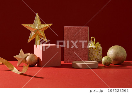 Background for the presentation of cosmetic products with Christmas concept. Front view of empty podiums decorated with cute yellow decorative accessory on red background 107528562