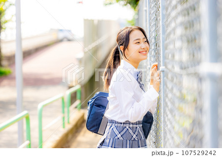 校舎の前に立つ制服を着た女子高生 107529242