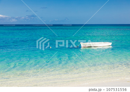 Seascape with boat near sandy beach and blue sky. 107531556