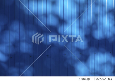 Background and texture of corrugated metal sheet of blue color with the effect of shadows from wood Background and texture of corrugated metal sheet of blue color with the effect of shadows from wood 107532163