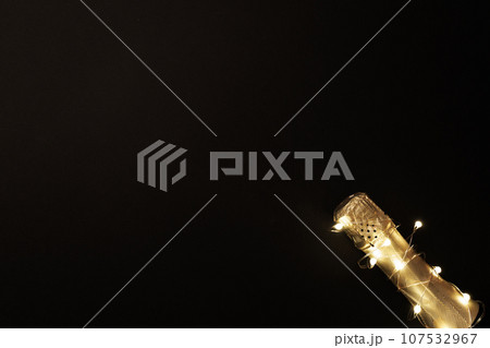 Champagne bottle with garlands on color background 107532967