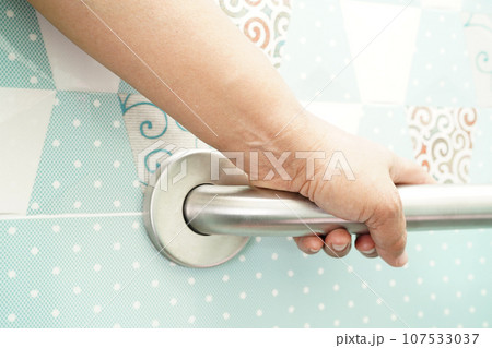 Asian woman patient use toilet support rail in bathroom, handrail safety grab bar, security in nursing hospital. Asian woman patient use toilet support rail in bathroom, handrail safety grab bar, security in nursing hospital. 107533037