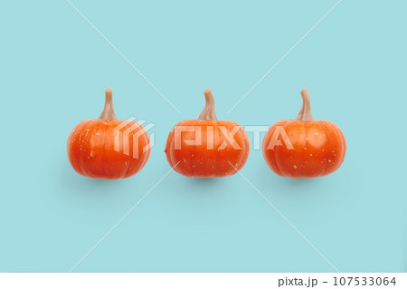 Three orange pumpkins on pastel color background 107533064