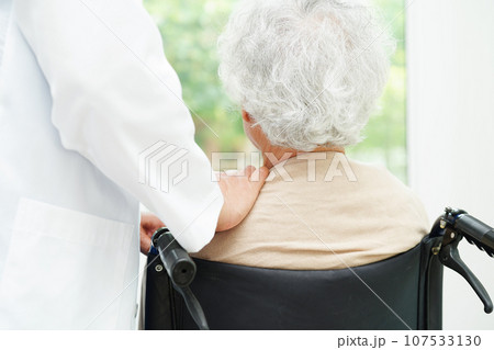 Doctor help Asian elderly woman disability patient sitting on wheelchair in hospital, medical concept. Doctor help Asian elderly woman disability patient sitting on wheelchair in hospital, medical concept. 107533130