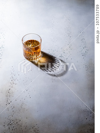 Whiskey in crystal glass with ice cubes and black shadow.Top view. 107533789