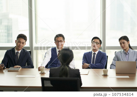 female asian candidate being interviewed by a group of business people 107534814