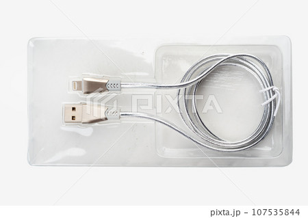 Silver-colored USB cable in plastic packaging on a white background. 107535844