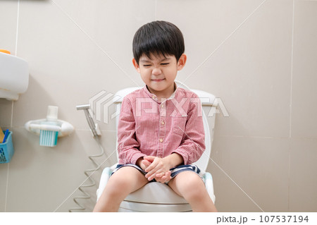 Asian boy Sitting on the toilet bowl Asian boy Sitting on the toilet bowl 107537194