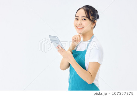 電卓を使うエプロン姿の若い主婦 107537279