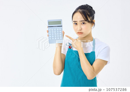電卓を使うエプロン姿の若い主婦 電卓を使うエプロン姿の若い主婦 107537286