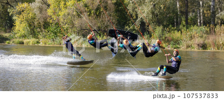 Sportsman on wakeboard performing back roll inversion on the river 107537833