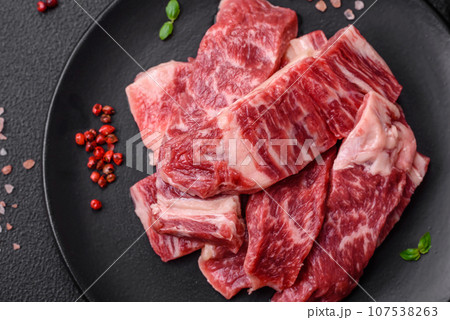 Fresh juicy raw beef slices with salt and spices 107538263