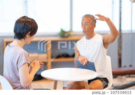スポーツジムでカウンセリングをするシニア男性 107539015