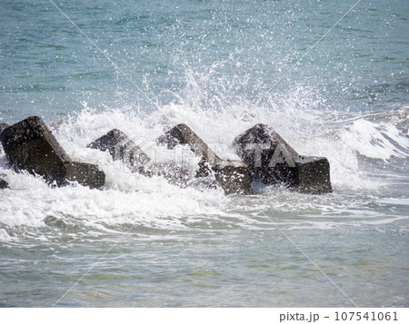 海岸の消波ブロックに波が打ち寄せて波飛沫が上がる。 海岸の消波ブロックに波が打ち寄せて波飛沫が上がる。 107541061