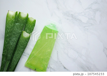 Fresh aloe vera sliced and liquid gel in plastic container on white background  107545233