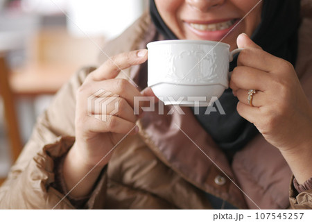 women holding a coffee cup  107545257