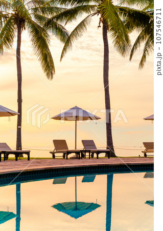 Umbrella and chair around swimming pool in resort hotel for leisure travel and vacation neary sea ocean beach 107546711