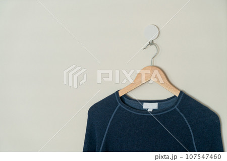 navy sweater hanging with wood hanger 107547460