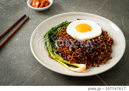 dried Korean spicy black sauce instant noodles with fried egg and kimchi 107547617