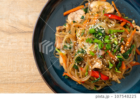 japchae or stir-fried Korean vermicelli noodles with vegetables and pork topped with white sesame japchae or stir-fried Korean vermicelli noodles with vegetables and pork topped with white sesame 107548225