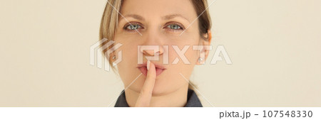 Woman puts index finger to mouth asking to keep silence Woman puts index finger to mouth asking to keep silence 107548330
