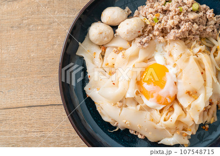 dried spicy noodles with minced pork, meatballs and egg 107548715