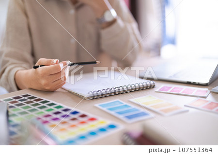 Fashion designer women read data on laptop to designing new dress collection and sketching in paper 107551364