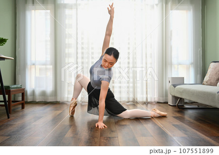 Beautiful woman in pointe shoes practicing ballet at home. People, dance and art concept Beautiful woman in pointe shoes practicing ballet at home. People, dance and art concept 107551899