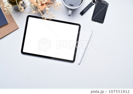 Top view of digital tablet, stylus pen, notebook and coffee cup on white office desk 107551912