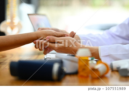 Close up doctor holding hand of elderly patient. Medical care and support concept 107551989
